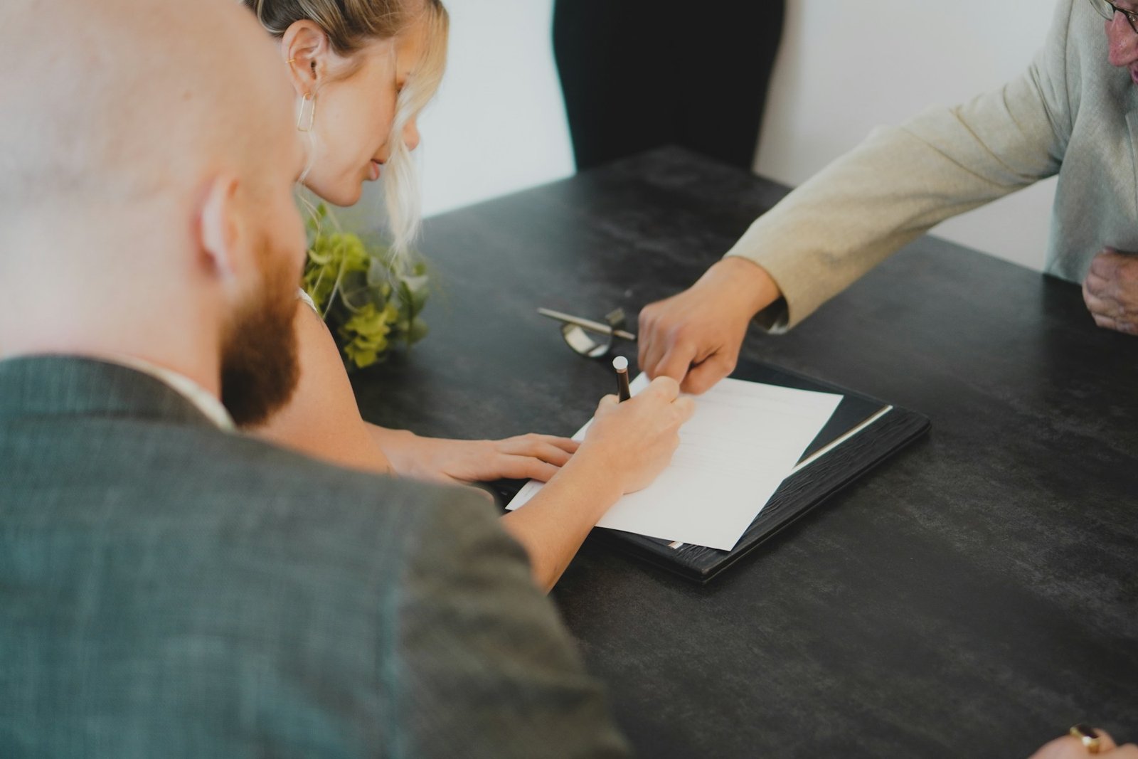 Couple signing an official document at a desk
