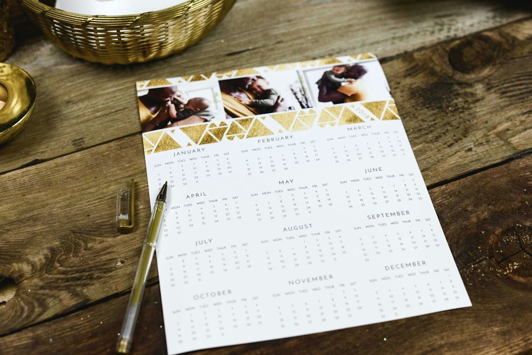 Printed yearly calendar and pen on a wooden table