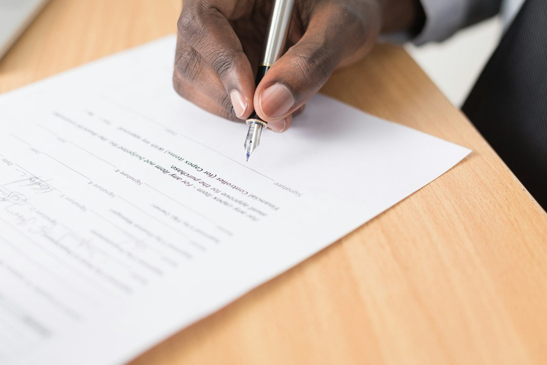 Hand signing a paper form with a fountain pen